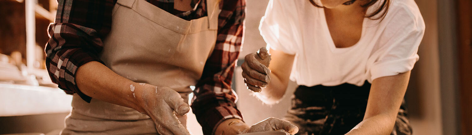Ann Vanino's approach to coaching - image one one woman helping another learn to make pottery