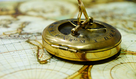 New Directions Coaching with Ann Vanino - image of polished brass compassions on antique map