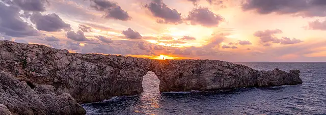 Coaching for a New Era with Ann Vanino, Image of a natural arch on a promontory, with the sun breaking through